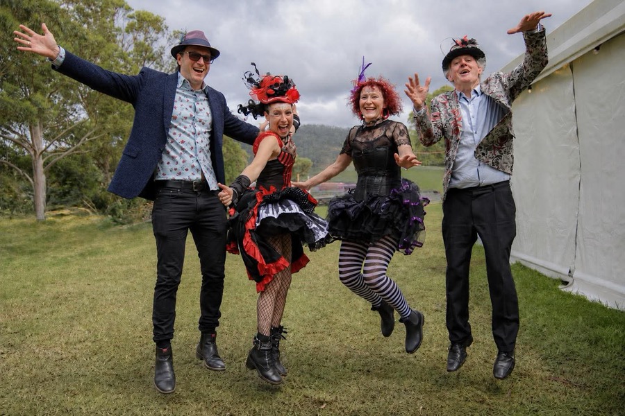 Band jumping for joy on the grass at a festival