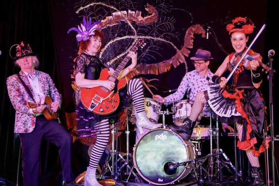 Band rocking out on stage with guitar, violin, mandolin and drums